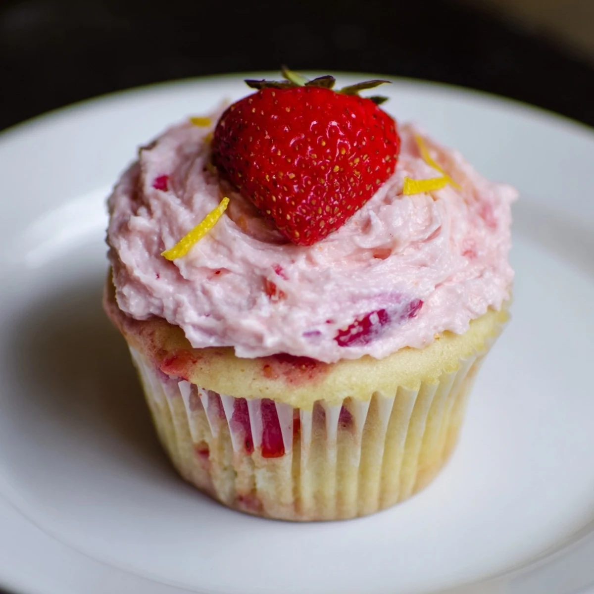 A plate of Strawberry Lemonade Cupcakes, fluffy crumb, bright citrus aroma.