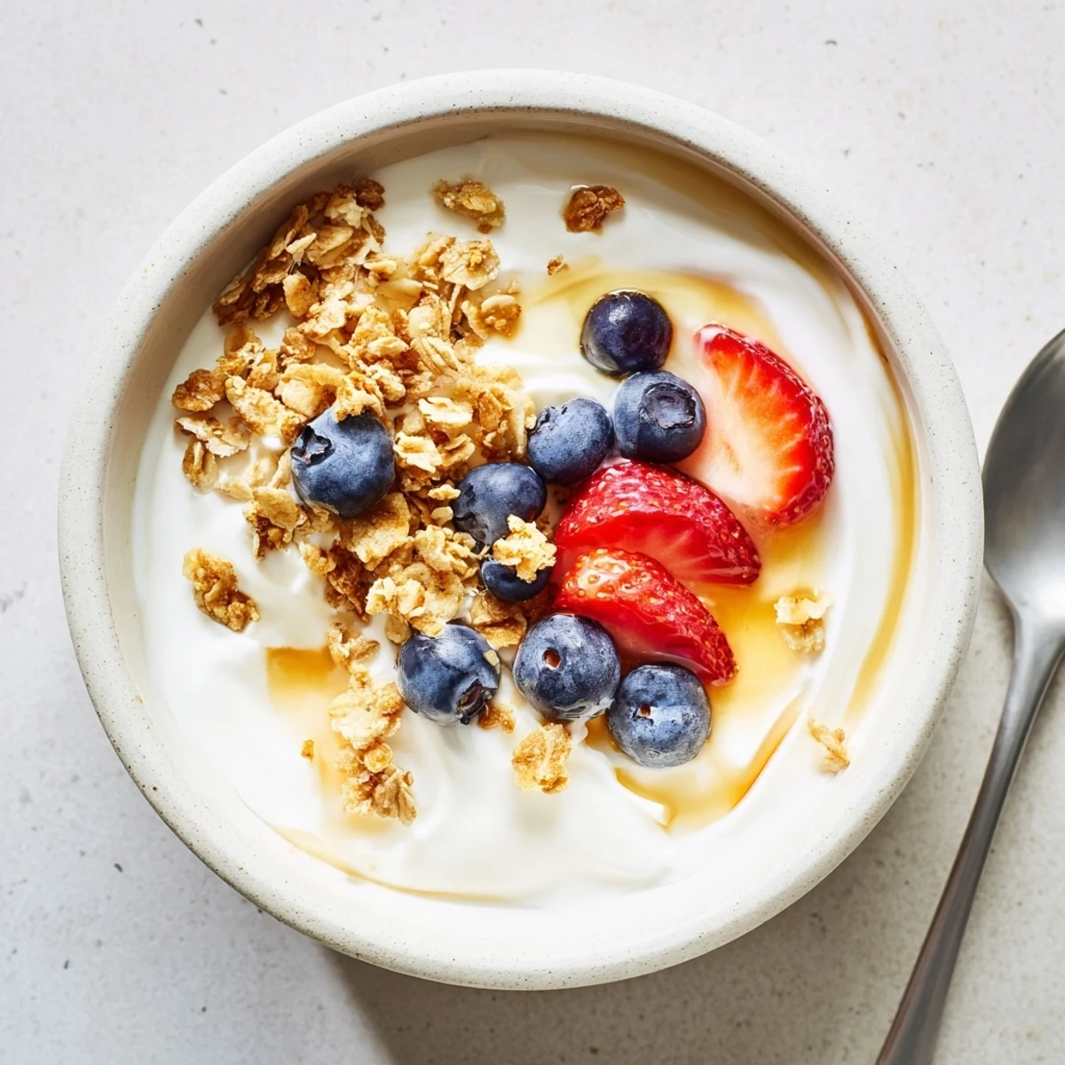 Creamy homemade yogurt served in glass jars topped with fresh berries