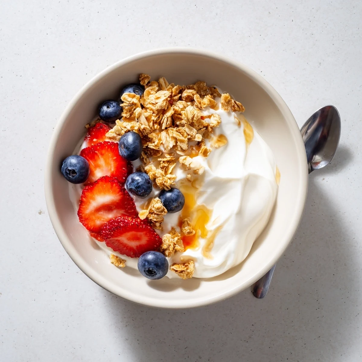Thick tangy homemade yogurt drizzled with golden honey and scattered granola