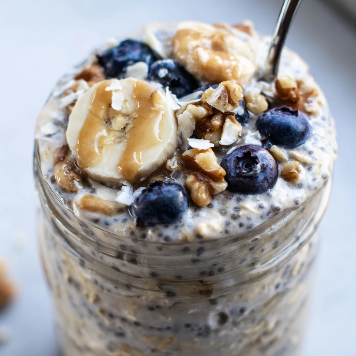 Thick protein overnight oats layered with banana slices and chopped nuts